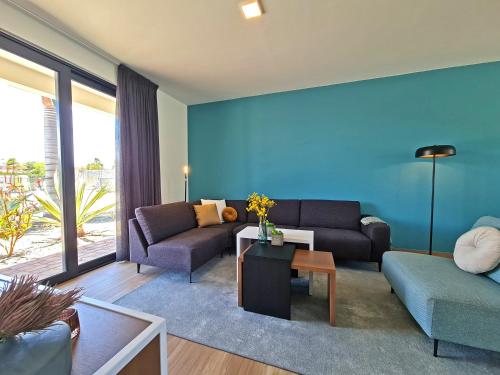 a living room with two couches and a blue wall at Tuscany Residence Aruba in Palm-Eagle Beach