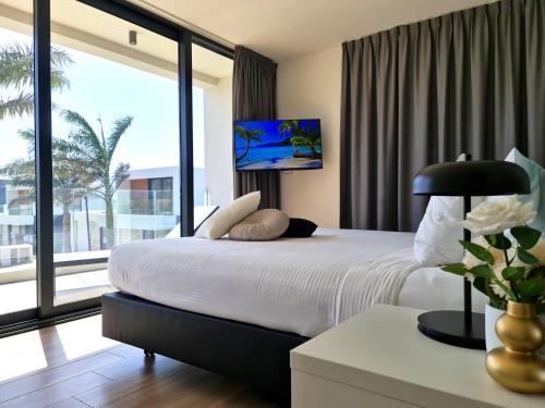 a bedroom with a large bed and a large window at Tuscany Residence Aruba in Palm-Eagle Beach