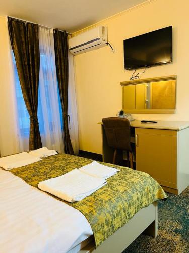 a hotel room with a bed and a desk at Hotel La Ane in Babadau