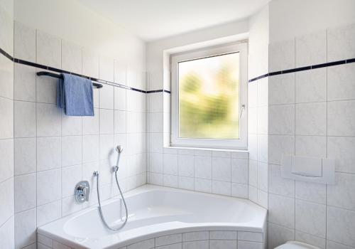 a white bathroom with a tub and a window at Garni-Hotel Sailer & Hotel Sailer´s Villa in Rottweil