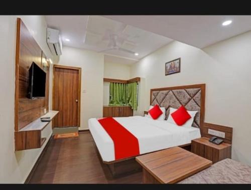 a bedroom with a large bed with red pillows at hotel swagat inn in Ahmedabad