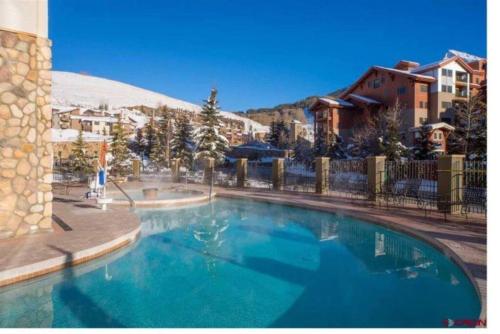 a large blue swimming pool in front of a building at Grand Lodge in Crested Butte