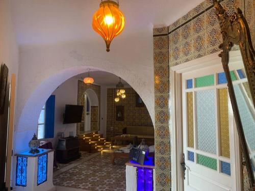een kamer met een boog en een woonkamer bij Charming house in Arabesque style in Hammamet Nord