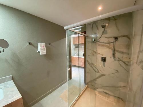 uma casa de banho com uma cabina de duche em vidro em ILE DE PIPA Oásis - By Almare Flats em Pipa