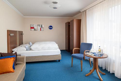 a hotel room with a bed and a table and a couch at Garni-Hotel Sailer & Hotel Sailer´s Villa in Rottweil