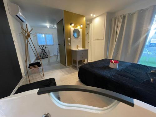 La salle de bains est pourvue d'une baignoire, d'un lit et d'un lavabo. dans l'établissement Studio M romantisme et élégance, à Pézenas