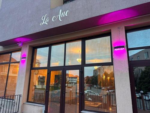 un magasin avec des lumières violettes à l'avant d'un bâtiment dans l'établissement Hotel La Ane, à Babadau