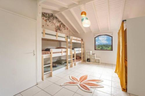- une chambre avec des lits superposés et une chambre avec une fleur à l'étage dans l'établissement Spacieuse VILLA COROSSOL avec piscine, au Gosier