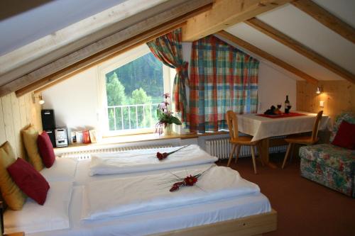 sypialnia z 2 łóżkami, stołem i oknem w obiekcie Alpina Residence w mieście Solda