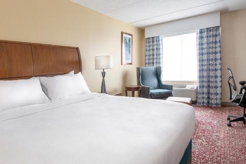a hotel room with a bed and a chair and a window at Hilton Garden Inn Cleveland Downtown in Cleveland