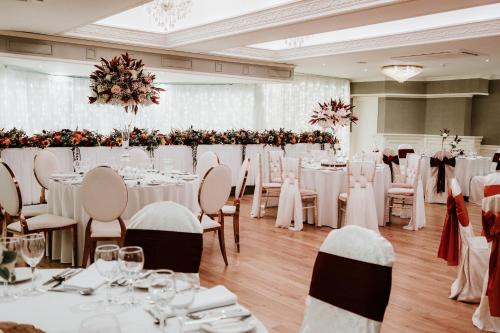 a banquet hall with white tables and chairs at Bushtown Hotel & Spa in Coleraine