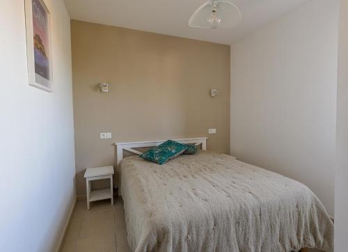 une chambre avec un lit avec une couverture dessus dans l'établissement MAISONNETTE LOZARI 4 PERS PROCHE L'ILE ROUSSE, à Belgodère