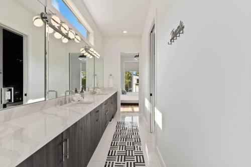 a bathroom with two sinks and a large mirror at Luxurious 4bd home sleeps 12 minutes to downtown with parking in Nashville