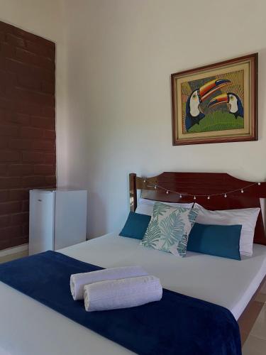 a bedroom with two beds and a refrigerator at Suites Vossoroca in Alto Paraíso de Goiás