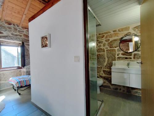 a bathroom with a stone wall and a sink at Aldeia de Pontes - Castro Laboreiro in Castro Laboreiro