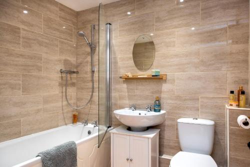 a bathroom with a sink and a toilet and a shower at Cosy Cottage rural village near Tavistock/sleeps 4 in Bere Alston