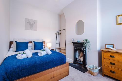 a bedroom with a blue bed and a fireplace at Central 2-bed home in Chester by 53 Degrees Property - Amazing location, Ideal for Couples - Sleeps 4! in Chester