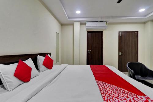 a bedroom with a large bed with red pillows at Ak Pride in Vijayawāda