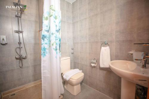 Palm Inn Suites Hotel في الغردقة: حمام مع مرحاض ومغسلة
