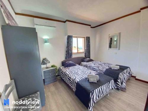 a bedroom with two beds and a window at HIMALAYA ROOFTOP Sea VIEW in Albufeira