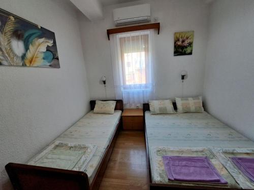 2 Betten in einem Zimmer mit Fenster in der Unterkunft Gjorgji Apartments 68a in Ohrid