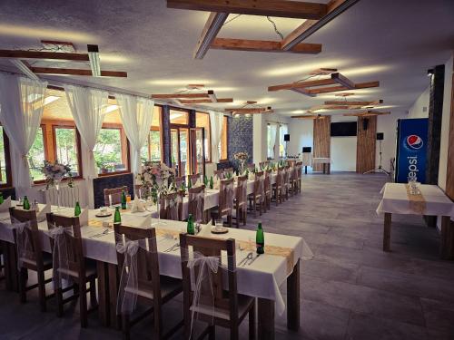 un comedor con mesas y sillas y botellas. en Hotel Krpáčovo en Krpacovo