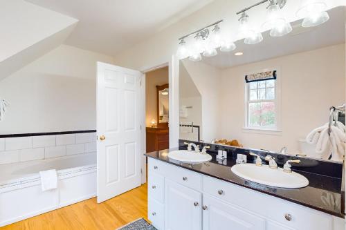 a bathroom with two sinks and a large mirror at Meadow View Retreat in Stowe