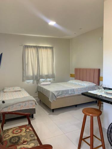 - une chambre avec 2 lits, une table et des chaises dans l'établissement Lavínia loft 5, à Búzios