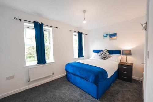 sypialnia z niebieskim łóżkiem i 2 oknami w obiekcie The Luxury Inn, Birmingham w Birmingham