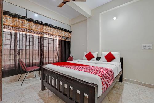 1 dormitorio con 1 cama grande con almohadas rojas en Oyo Flagship Sri Chowdeshwari Boarding And Lodging, en Bangalore