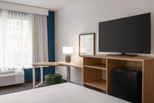 a hotel room with a bed and a flat screen tv at Spark By Hilton Mystic Groton in Mystic
