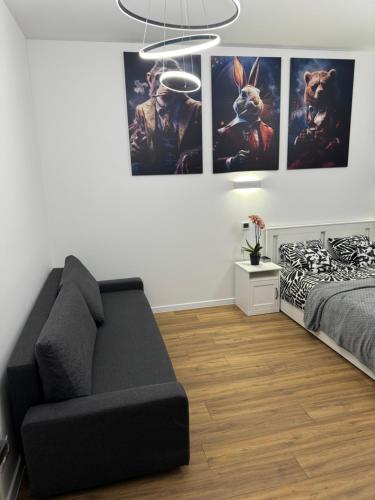 a bedroom with a couch and posters on the wall at Chicago Apartment in Katowice