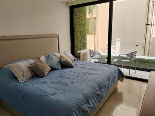a bed with blue sheets and pillows in a bedroom at NEW! Encantador estudio a unos pasos de la Playa By Yeah in Playa del Carmen