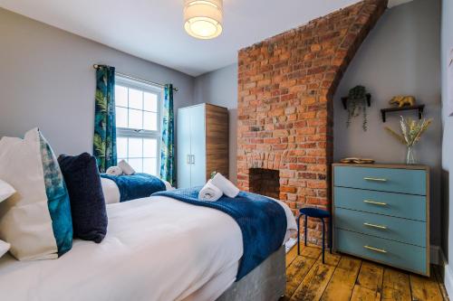 a bedroom with two beds and a brick wall at NEW! Gorgeous 2-bed home in Chester City Centre by 53 Degrees Property - Incredible location, Ideal for Small Groups - Sleeps 6! in Chester