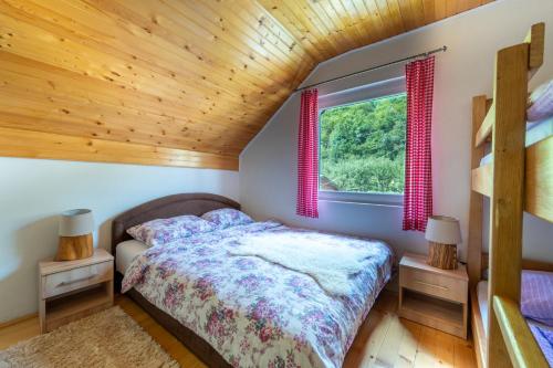 ein Schlafzimmer mit einem Bett und einer Holzdecke in der Unterkunft Domacinstvo na kraju svijeta in Šipovo