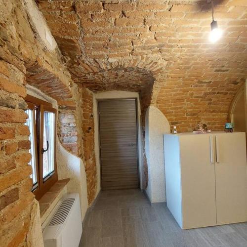 Camera con frigorifero e muro di mattoni di Istanti - Rosmarino a Costigliole Saluzzo