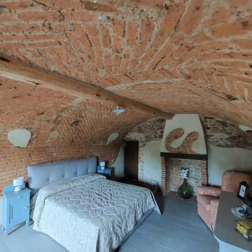 a bedroom with a bed in a brick wall at Istanti - Rosmarino in Costigliole Saluzzo