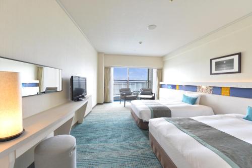 a hotel room with two beds and a television at Loisir Hotel Naha in Naha