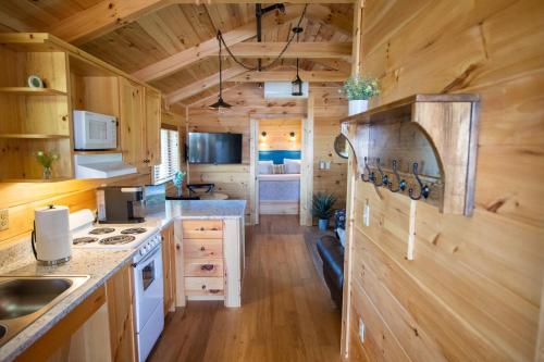 a kitchen with wooden walls and wooden flooring in a tiny house at Juneberry Ridge in Norwood