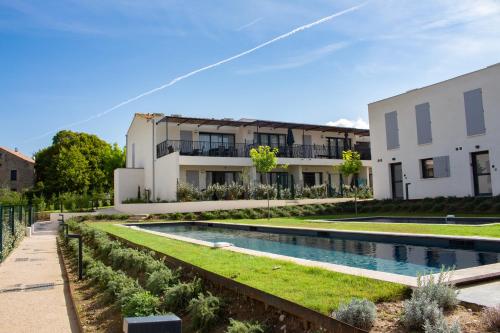 a villa with a swimming pool in front of a building at Les Papillons du Ventoux - Le Myrtil- éénslaapkamerappartement met terras en tuin in Malaucène