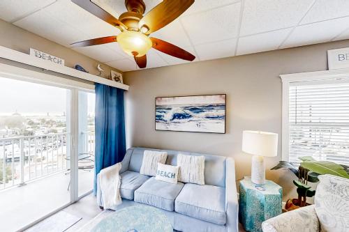 a living room with a couch and a ceiling fan at Skyline 406 in St. Pete Beach
