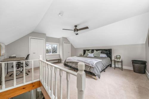 a white bedroom with a bed and a staircase at West Lake Nook: Near Sandbanks Park in West Lake