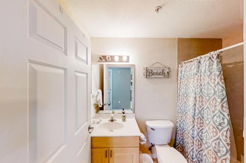 a bathroom with a white toilet and a sink at Skyline 406 in St. Pete Beach
