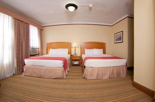 um quarto de hotel com duas camas e uma janela em Historic Plains Hotel em Cheyenne