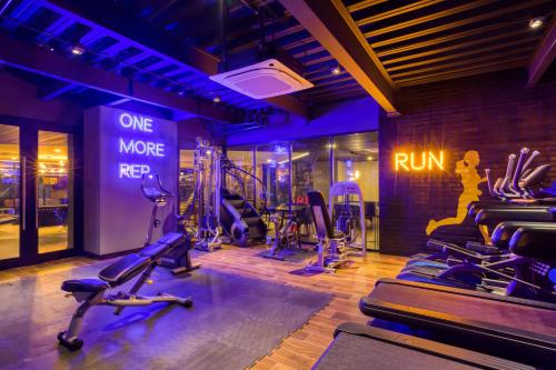 a gym with treadmills and exercise bikes in a room at Downtown Designer Apartments by ULIV in Tijuana