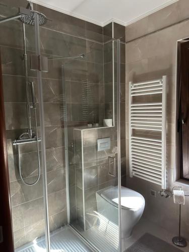 La salle de bains est pourvue d'une douche en verre et de toilettes. dans l'établissement Szent György Villa Apartmanház, à Hévíz
