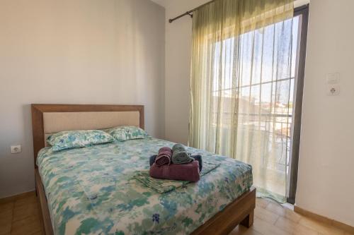 a bedroom with a bed and a large window at Deluxe Apartment LA in Larisa