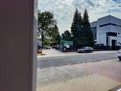 a view of a street with a parking lot with cars at Apartament 4 osobowy obok Szpitala Brzeziny 2 pokoje Prywatna łazienka i kuchnia 32m2 in Brzeziny