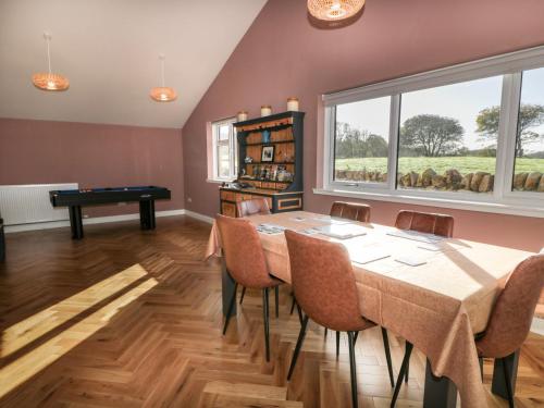 a dining room with a table and a pool table at Hardhills Cottage in Castle Douglas