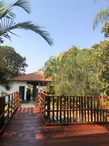 阿图尔诺盖拉Quarto de Casal Pousada Dos Ypês的一座木桥,通往一座树木繁茂的房屋